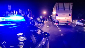 zdjęcie zdarzenia drogowego w Marzęcicach- po prawe stronie stoi samochód ciężarowy, po lewej widać radiowóz policyjny. W tle strażacy zabezpieczający miejsce