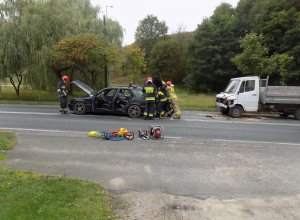 zdjęcie przedstawia dwa rozbite samochody. Po lewej stronie osobowy mercedes, za nim samochód ciężarowy
