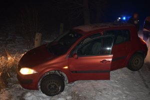 zdjęcie przedstawia czerwony samochód renault stojący na poboczu, w rowie