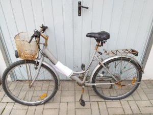 na zdjęciu widać rower w kolorze beżowym wraz z koszykiem zamontowanym na kierownicy
