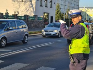policjant kieruje ruchem w rejonie przejścia dla pieszych