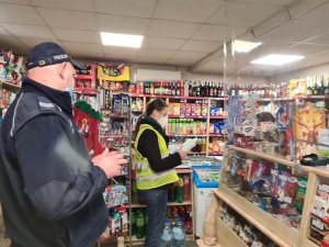zdjęcie przedstawia policjanta i pracownika Powiatowej Stacji Sanitarno-Epidemiologicznej podczas kontroli w sklepie