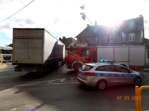 na zdjęciu widać samochód ciężarowy z niebieską naczepą oraz oznakowany radiowóz policyjny i wóz strażacki