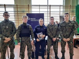 na zdjęciu widać policjantkę z młodzieżą przy stoisku policyjnym