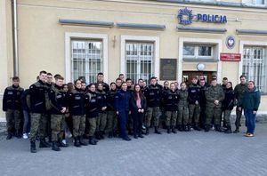 uczniowie pozują do wspólnego zdjęcia przed budynkiem komendy Policji
