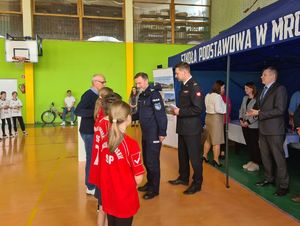 na zdjęciu widać Komendanta Powiatowego Policji w Nowym Mieście Lubawskim gratulującego jednej z drużyn