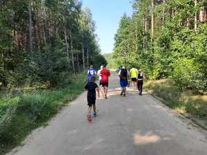 na zdjęciu widać uczestników biegnących leśną ścieżką