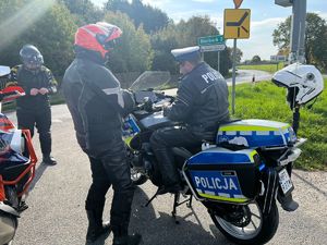 na zdjęciu widać policjanta na motocyklu przeprowadzającego kontrolę drogową