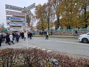 na zdjęciu widać policjanta kierującego ruchem przy cmenatarzu