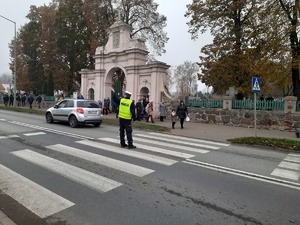 na zdjęciu widać policjanta kierującego ruchem w rejonie cmentarza