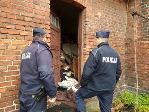 na zdjęciu widać dwóch umundurowanych policjantów sprawdzających pustostan