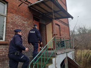 dwaj policjanci idą po schodach sprawdzić pustostan