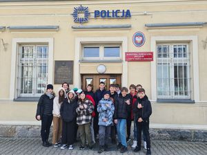 uczniowie stoją przy budynku Komendy Powiatowej Policji w Nowym Mieście Lubawskim