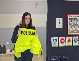 dzielnicowa pokazuje kamizelkę odblaskową