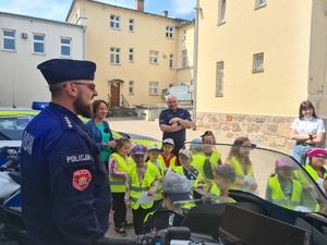 policjanci pokazują dzieciom radiowóz i motocykle