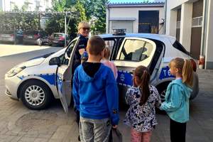policjant pokazuje dzieciom radiowóz