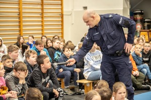 policjant rozmawia z dziećmi na temat bezpieczeństwa